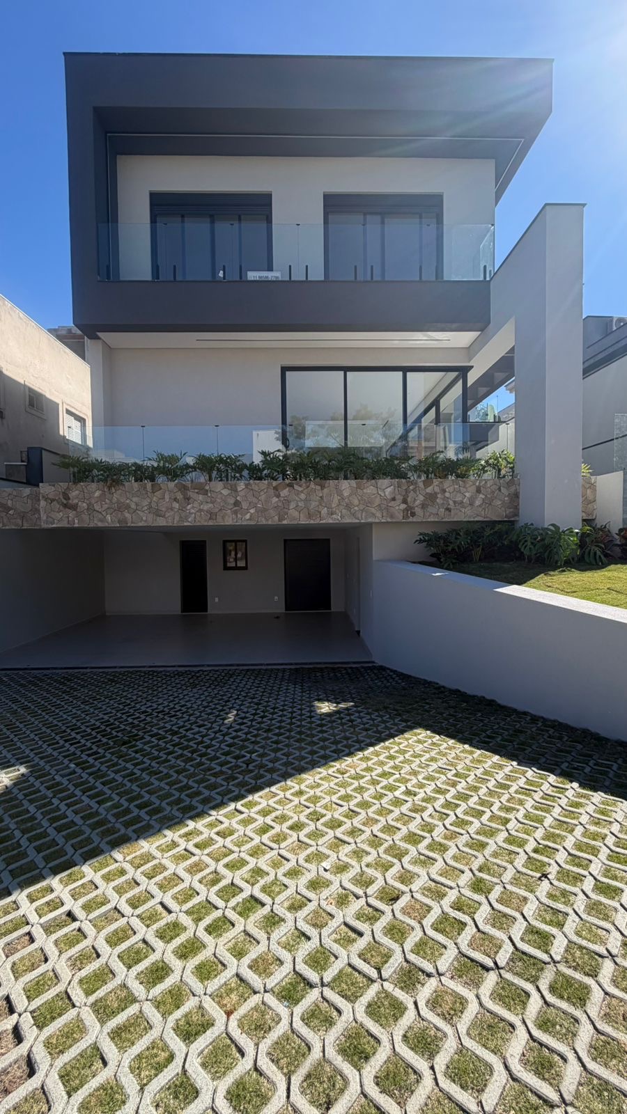 Acesso à garagem e fachada contemporânea do imóvel